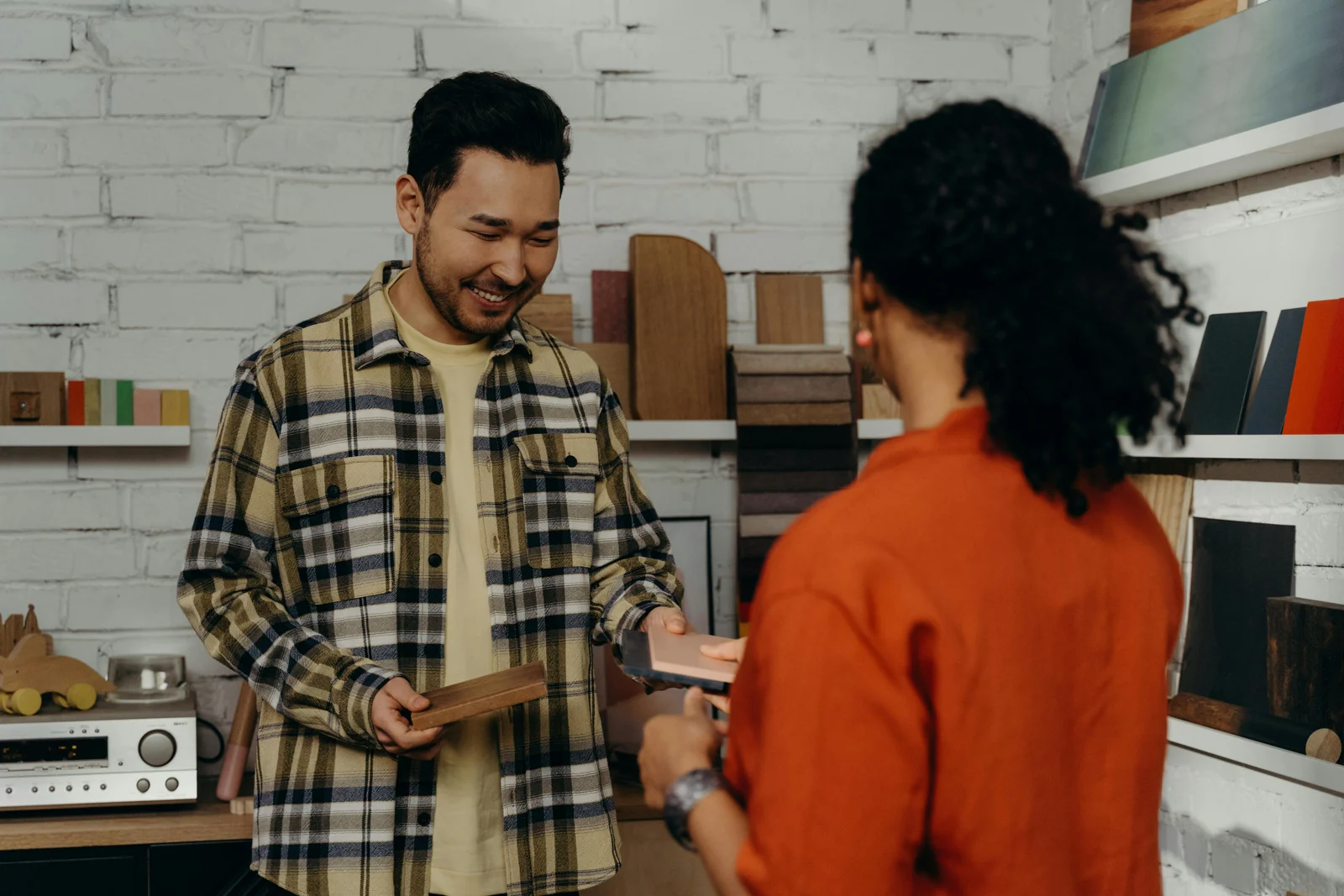 A dealer in a showroom presenting material samples and a configurator screen to a buyer, walking through the build options together.