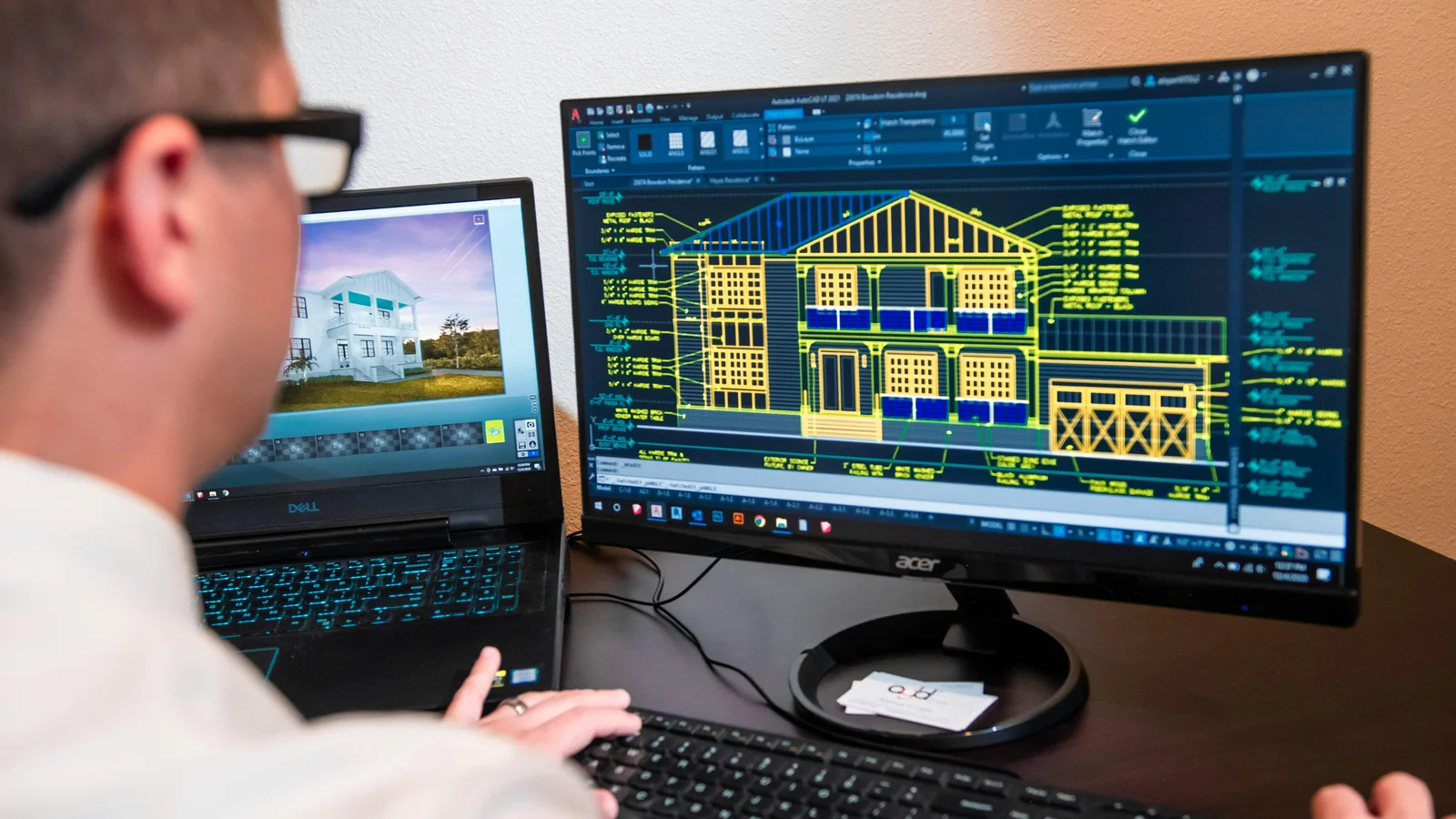 An architect reviews detailed residential designs on dual monitors at a modern office workstation, the same setup used to build and tune a digital showroom.