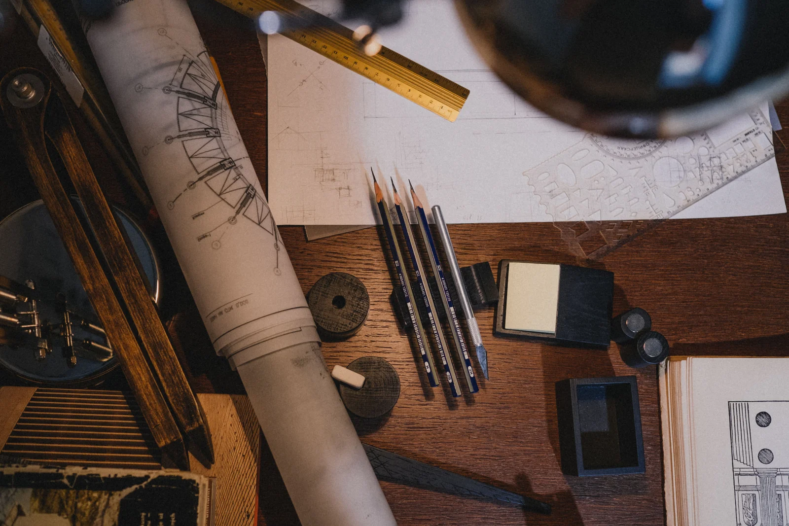 A cluttered workspace with architectural drawings, parts catalogues, and pencils, the kind of desk where compatibility rules get reconstructed from memory.
