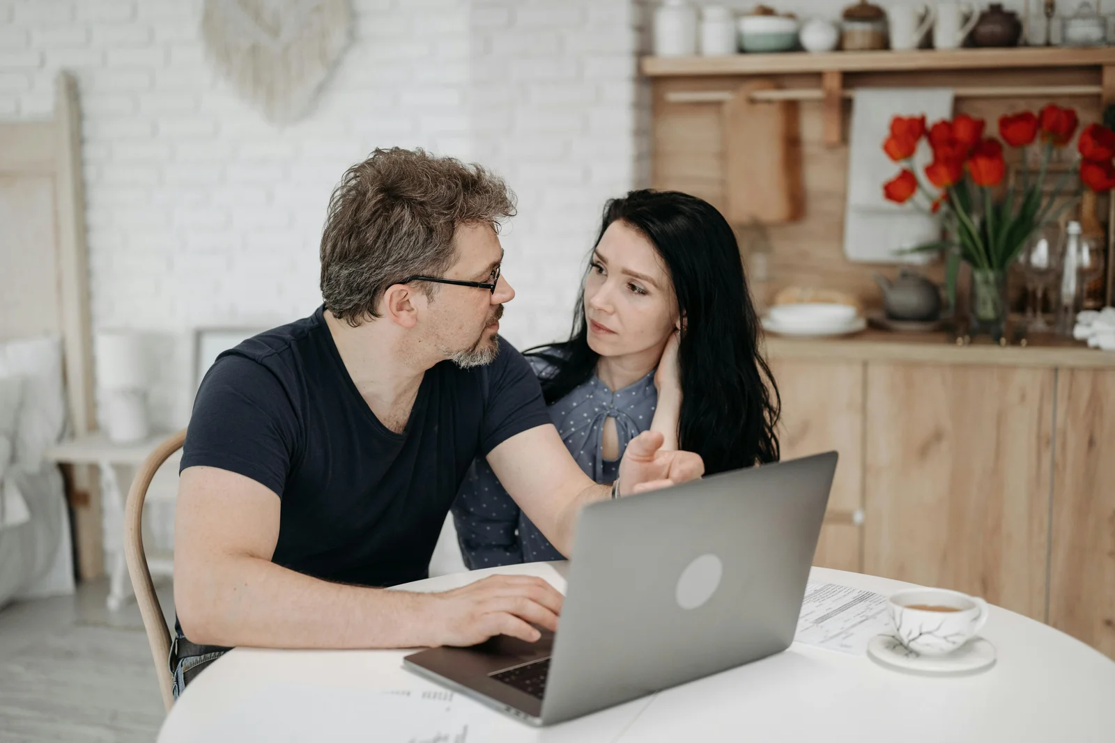 A couple at home looking at a laptop together on a Sunday evening, working through a product decision before they make a phone call to the dealer.