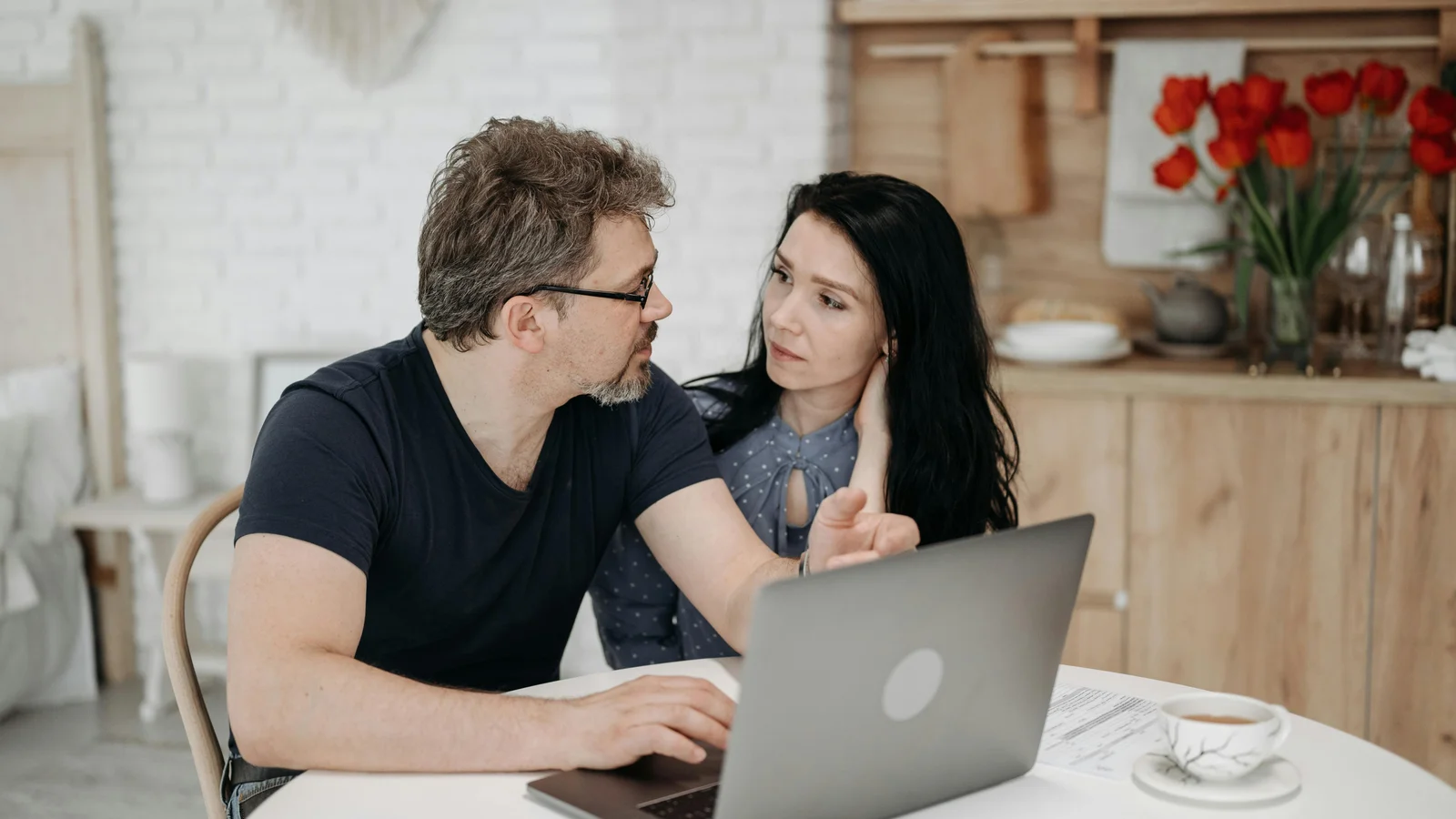 A couple sitting at home in front of a laptop, working through a product decision together on a Sunday evening.