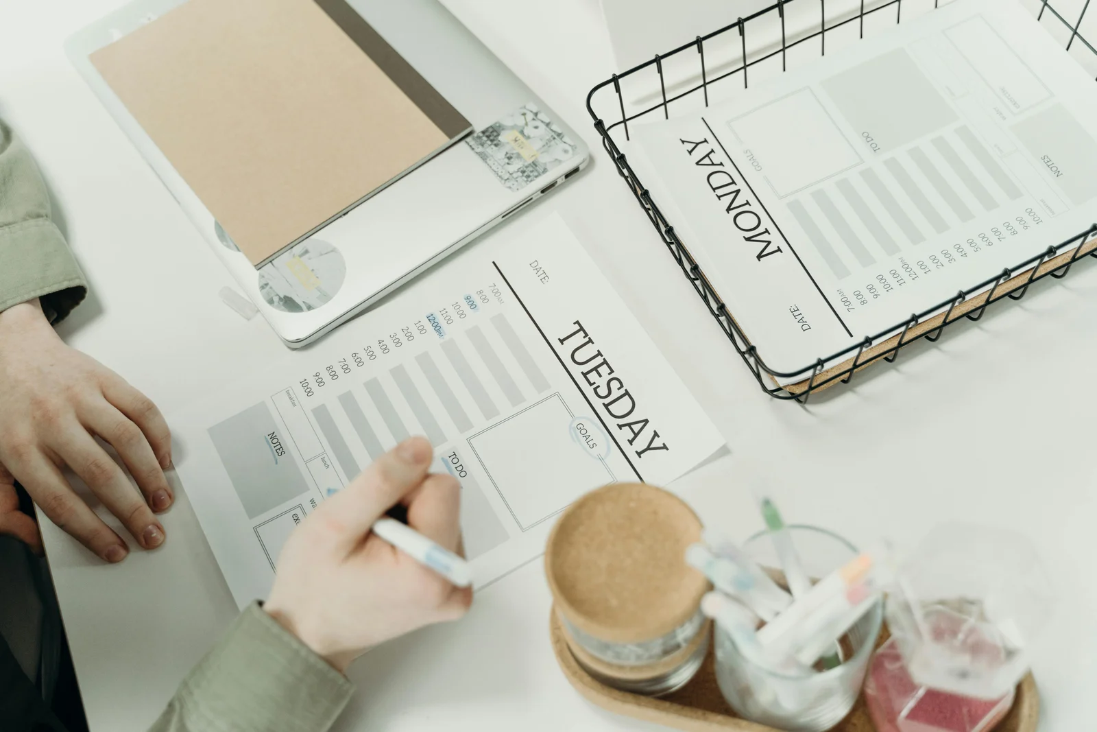 A professional organising the week with detailed schedule planners on a desk in an office, the kind of weekly planning surface where the translation work hides in plain sight.