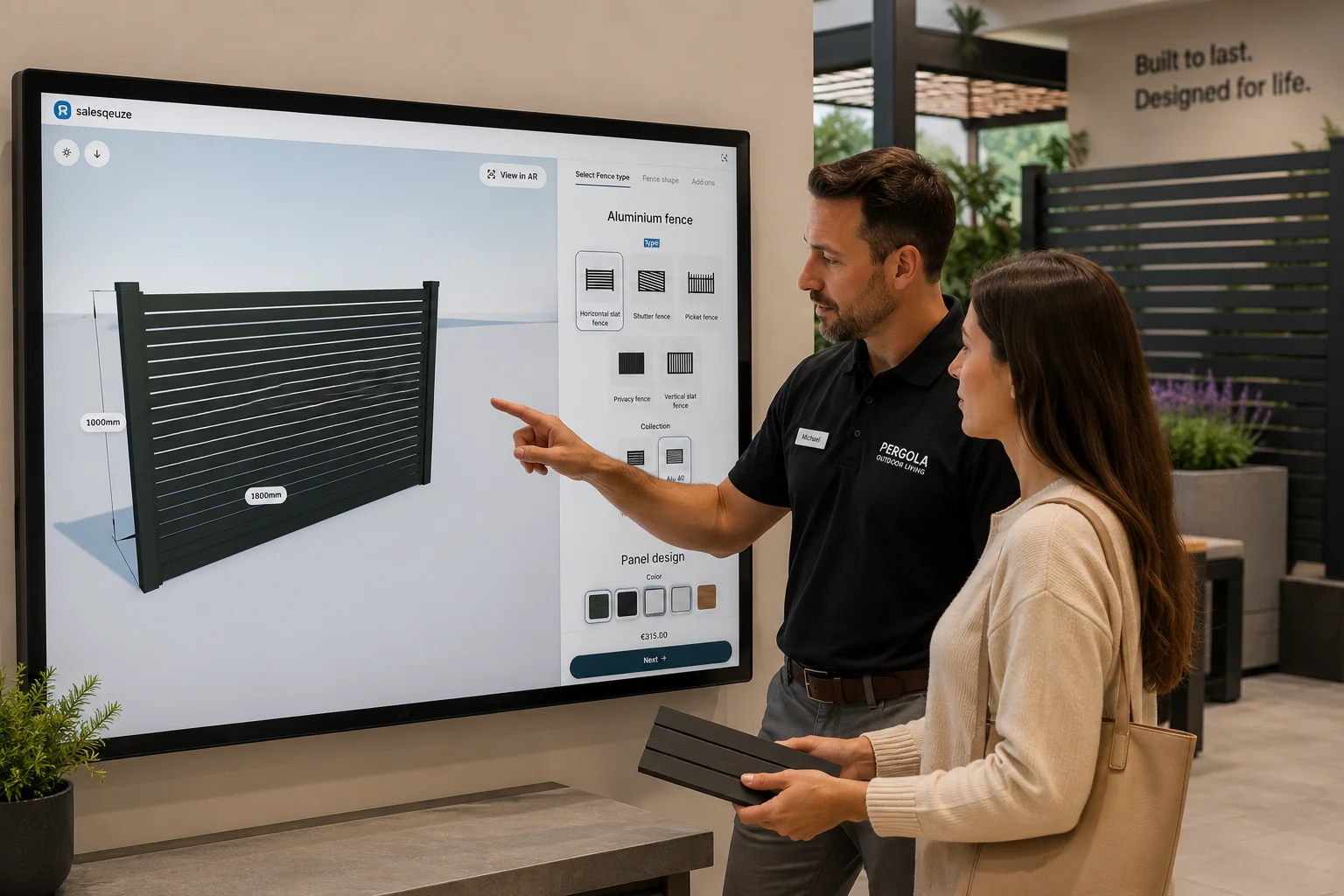 A seller and a customer choosing a fence together on a showroom wall screen.